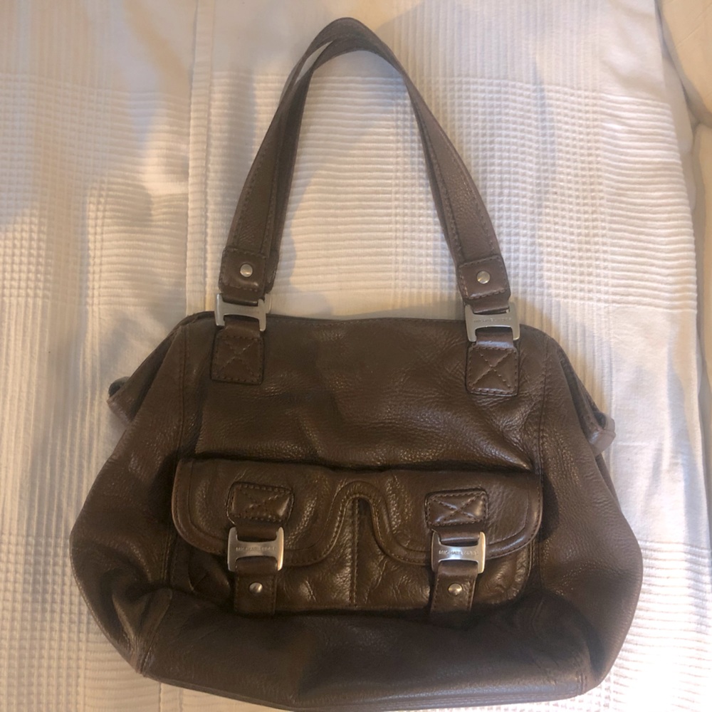 Michael Korrs purse with exterior pockets, spacious interior, & silver detail